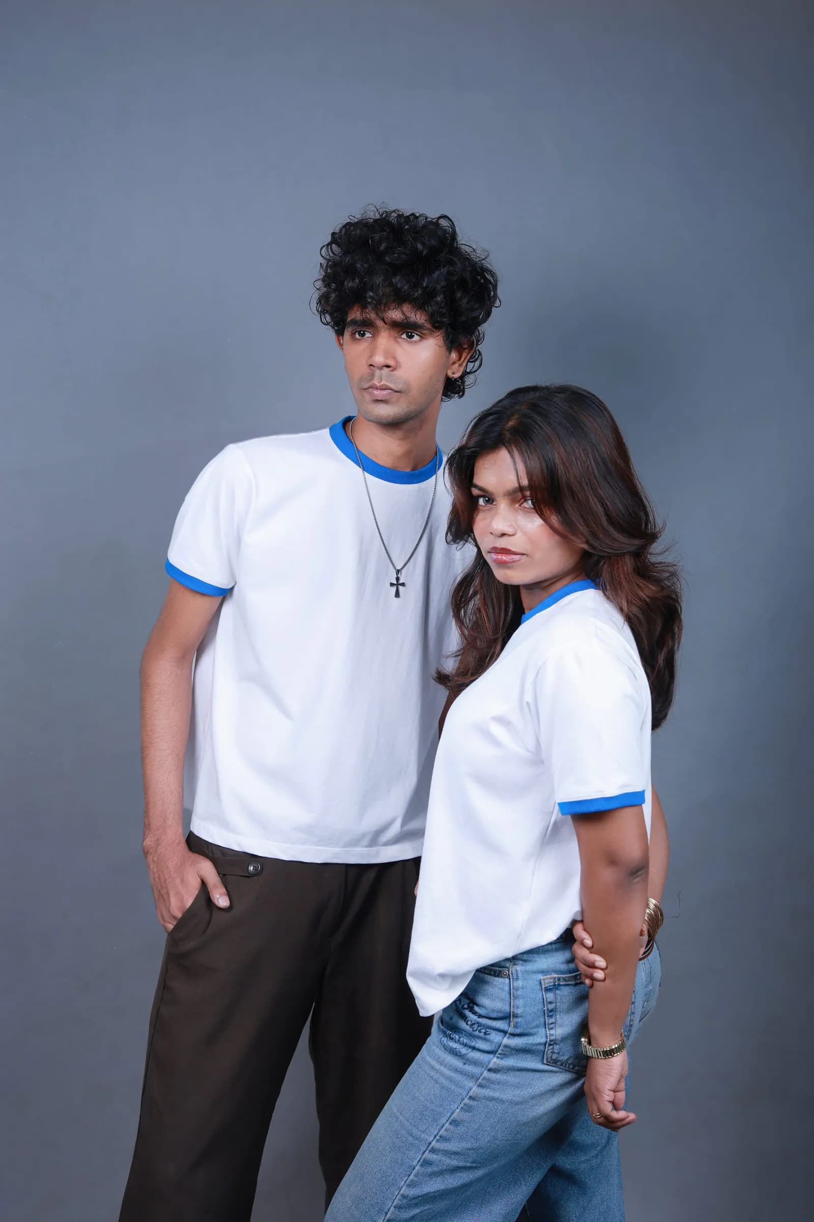 Two models wearing the Ringer Baby Tee, styled with denim and trousers